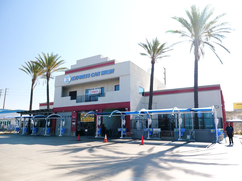 Front of the Happy Bubbles Ontario car wash with palm trees