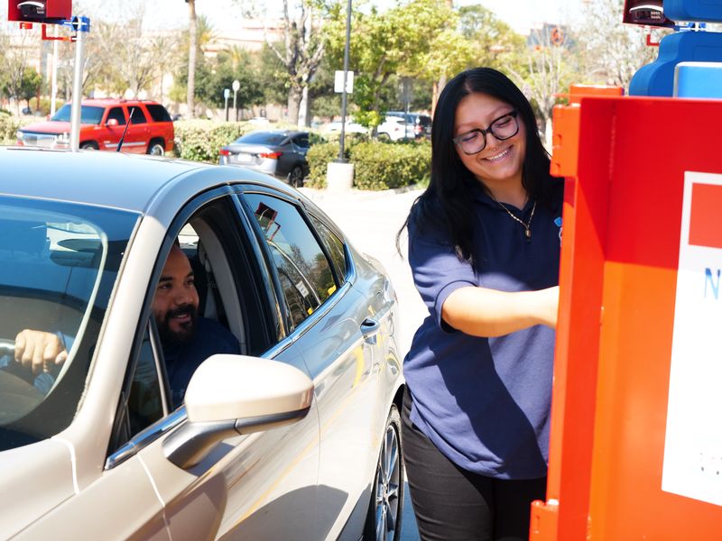 Team member smiling with a customer at the pay station