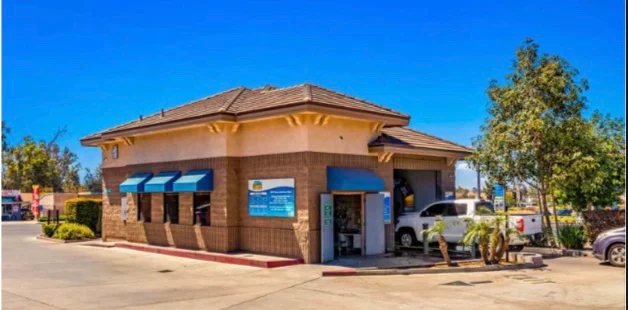 Happy Bubbles Jurupa Valley building with blue awnings and a truck exiting the tunnel