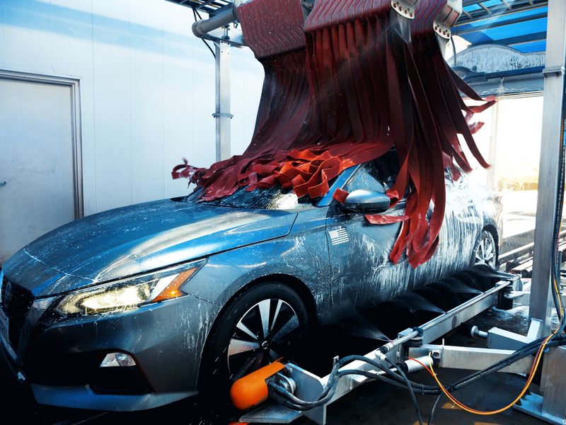 Red wrap brushes sweeping over a gray sedan