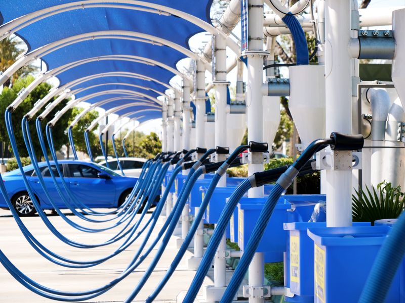 Row of free vacuum stations with blue hoses under shade canopies at Ontario